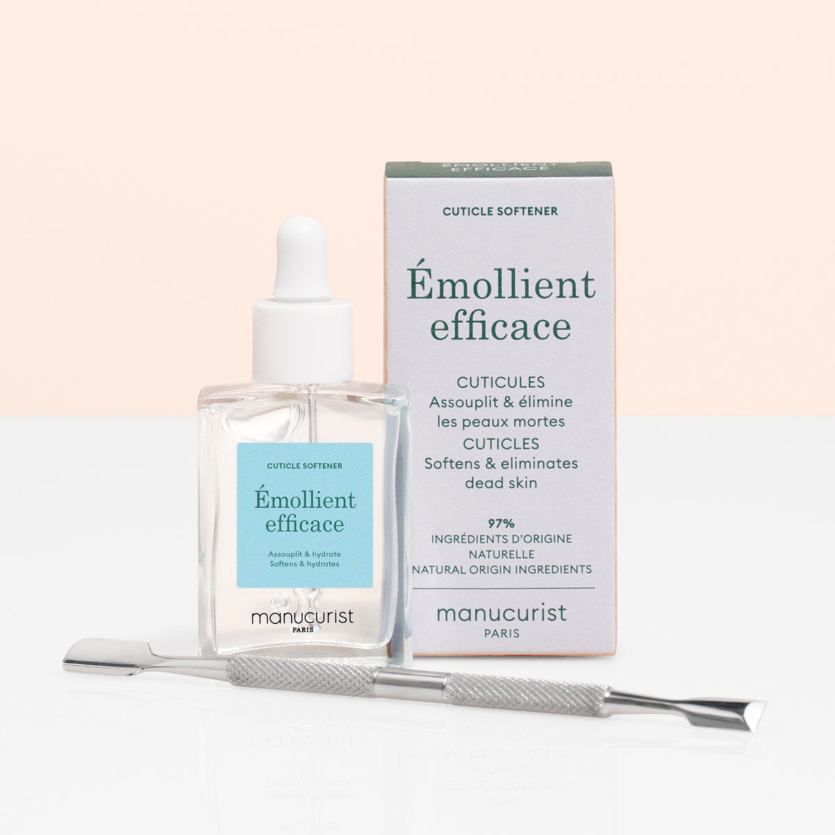 The Manucurist Cuticle Remover  Pusher Duo features a gentle cuticle remover with dropper and a metal pusher, shown beside its box on a white surface against a light pink background—ideal for easy nail care and dead skin removal.