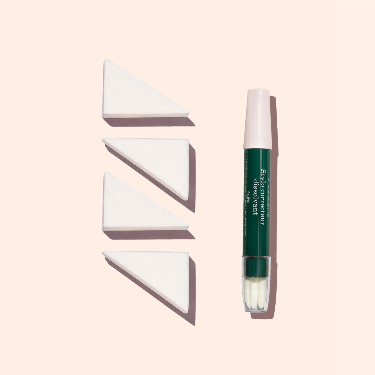 A Manucurist Nail Art Sponges - x4 set is displayed in a row next to a green and white concealer pen, all arranged vertically on a light beige background.