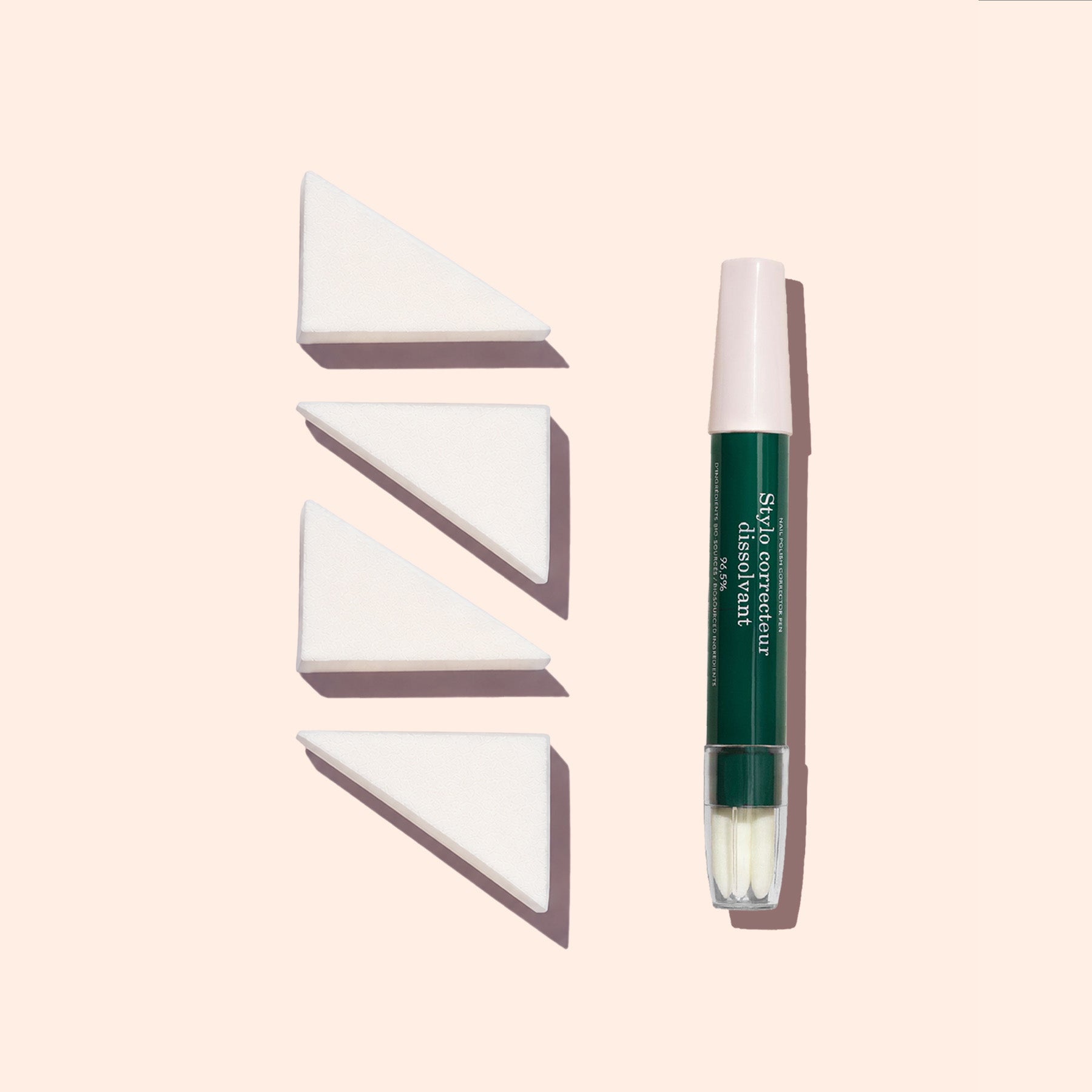 A Manucurist Nail Art Sponges - x4 set is displayed in a row next to a green and white concealer pen, all arranged vertically on a light beige background.