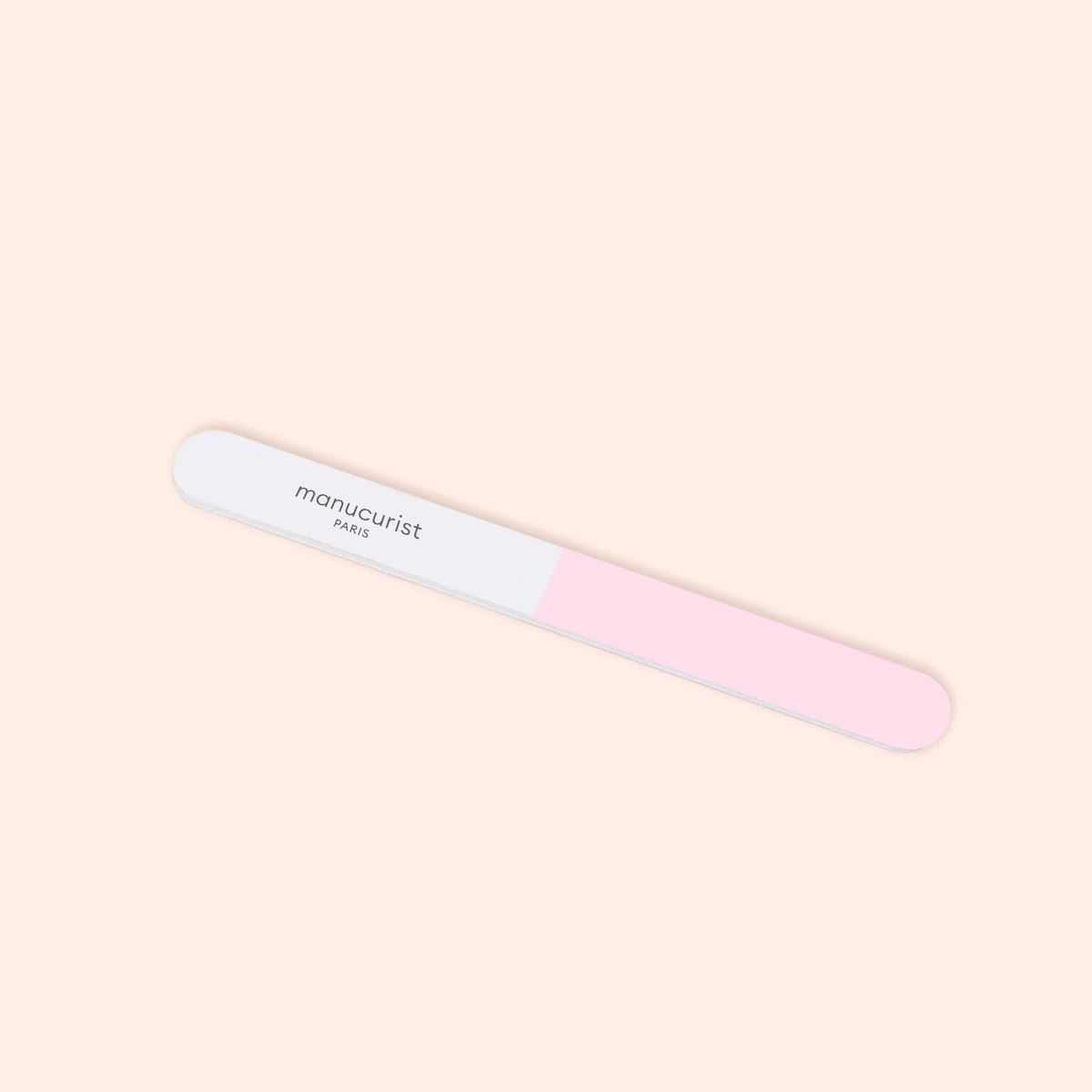 The Manucurist 3-way polisher, featuring “manucurist PARIS” and two tones—white left, pink right—on a light beige background, is perfect for smoothing nails before using your favorite buffer.