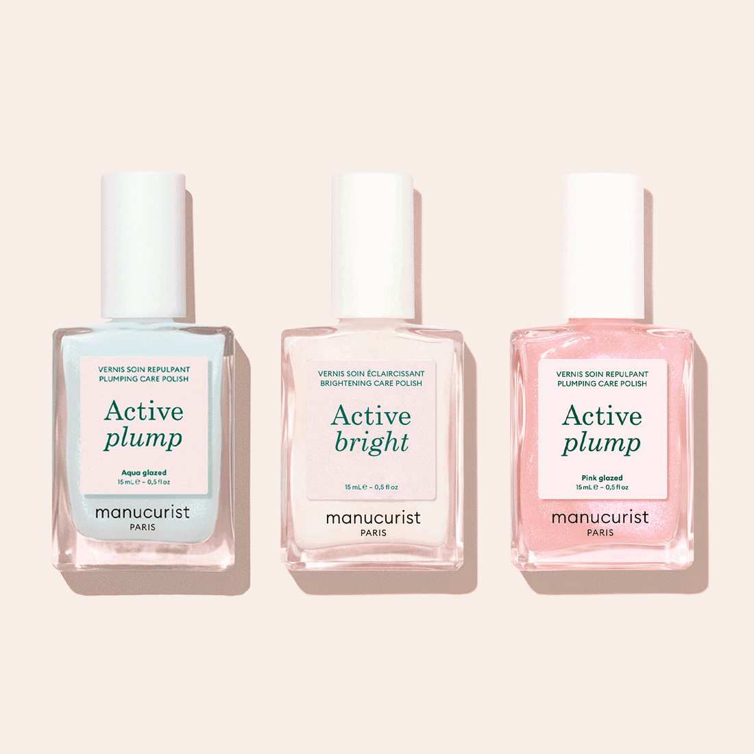 Three bottles of Manucurist Customisable Trio Active™ nail care polishes—Active Blur, Active Plump, and Active Bright—are displayed side by side on a light pink background, each delivering a unique effect for personalised nails.