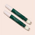 Two green and white Nail Polish Corrector Pens labeled “Stylo correcteur dissolvant” lie diagonally on a light beige background. The clear caps reveal fine tips, ideal for cleaning up gel polish.