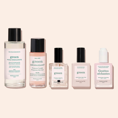 Five bottles of Manucurist manicure products, including Green Nail Polish Removing Oil, nail prep, nail strengthener, and quick-dry drops, are displayed in a row on a light beige background.
