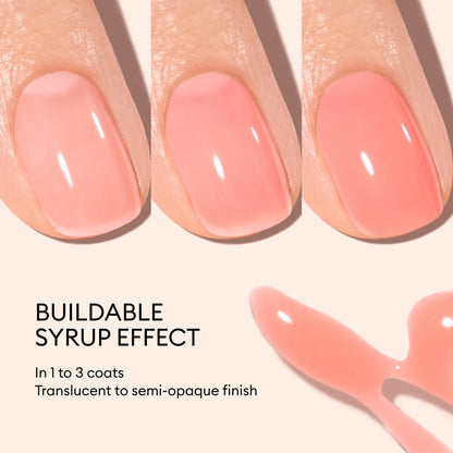 Three fingernails painted with Manucurist Glacé, a peach-pink jelly polish, shown in 1–3 coats from translucent to semi-opaque. Below is a pink polish smear and text: “BUILDABLE SYRUP EFFECT. In 1 to 3 coats. Translucent to semi-opaque finish.”.