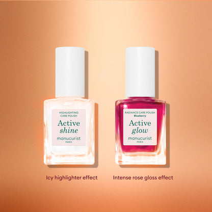 Two travel-size Manucurist nail polish bottles are displayed on a soft orange gradient background. On the left is Active™ Shine (clear), and on the right is Active™ Glow (pink). Text below reads: Achieve an icy highlighter effect or an intense rose gloss—perfect for elevating your nail care routine or adding a sparkling touch to any holiday gift set with the Active™ Travel-Size Duo.