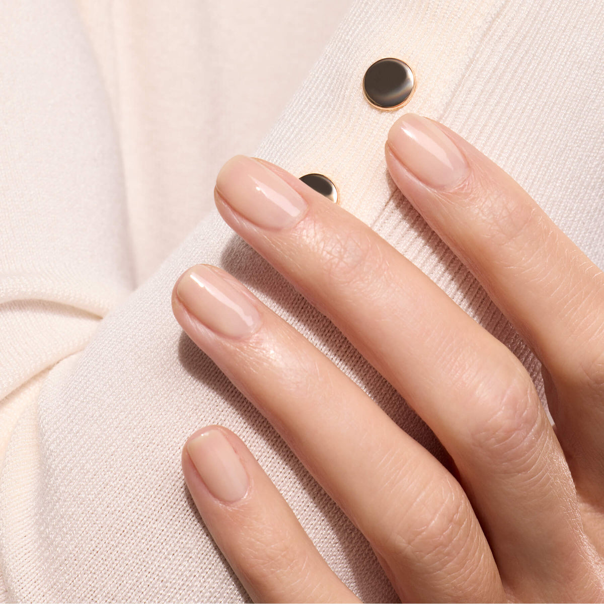 A hand with neatly manicured nails painted in Manucurist&