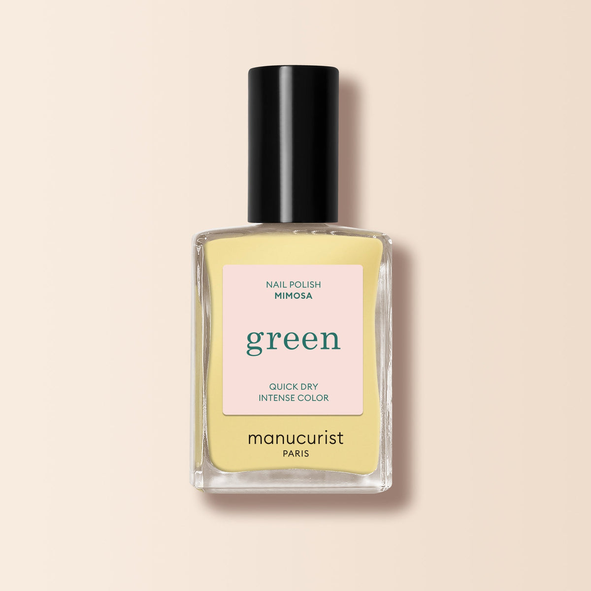 A bottle of Manucurist nail polish in the shade Mimosa, featuring pastel yellow color and a square bottle with a black cap, displayed on a soft beige background.