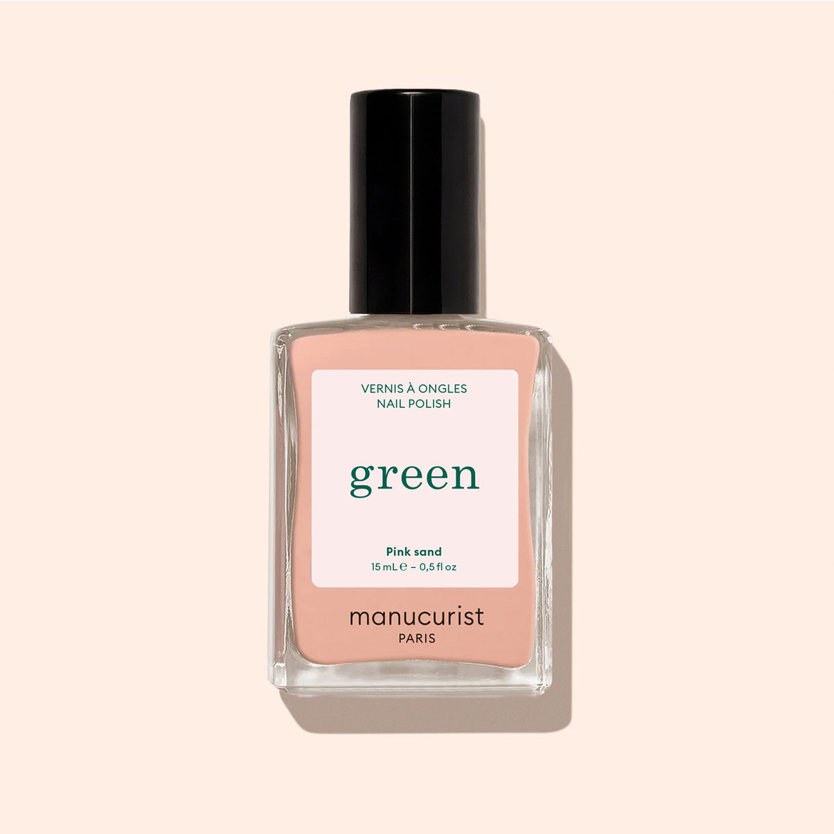 Manucurist Pink Sand nail polish features a peach-pink shade with subtle orange undertones in a clear rectangular bottle topped with a black cap.