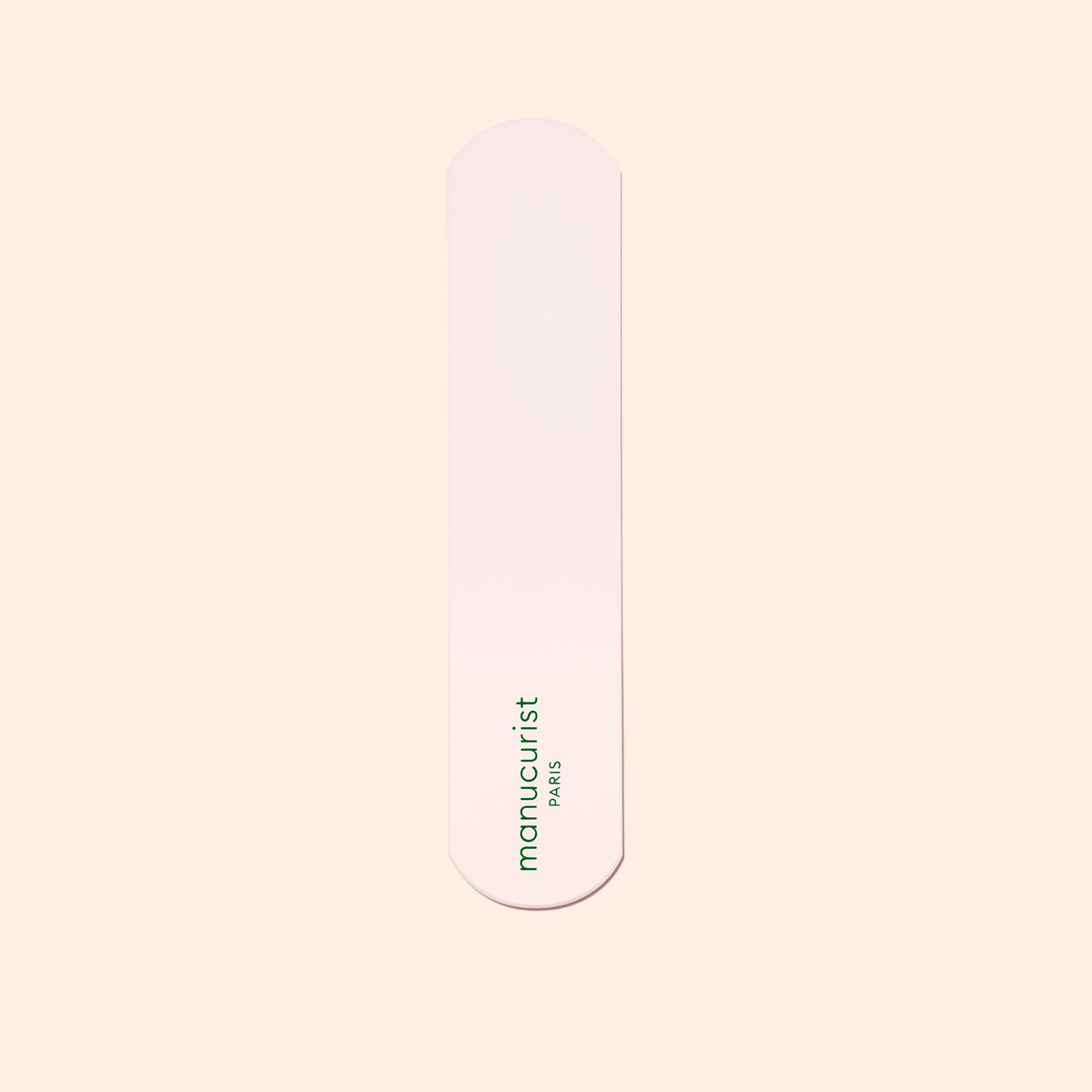 A pink nail file with rounded ends, printed with "manucurist PARIS" in green, sits on a light beige background—ideal to use with the Manucurist Glass Foot File to exfoliate your heels and reveal soft, smooth skin.