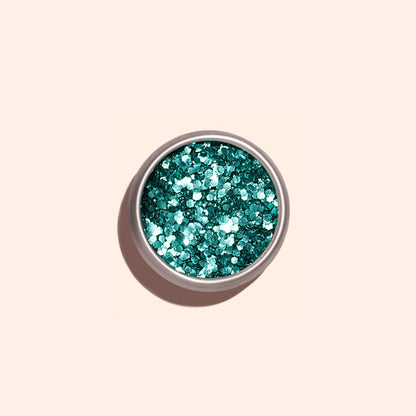 A small round container of Manucurist Turquoise biodegradable glitter viewed from above against a light beige background—ideal for adding an eco-friendly sparkle to your nail art.