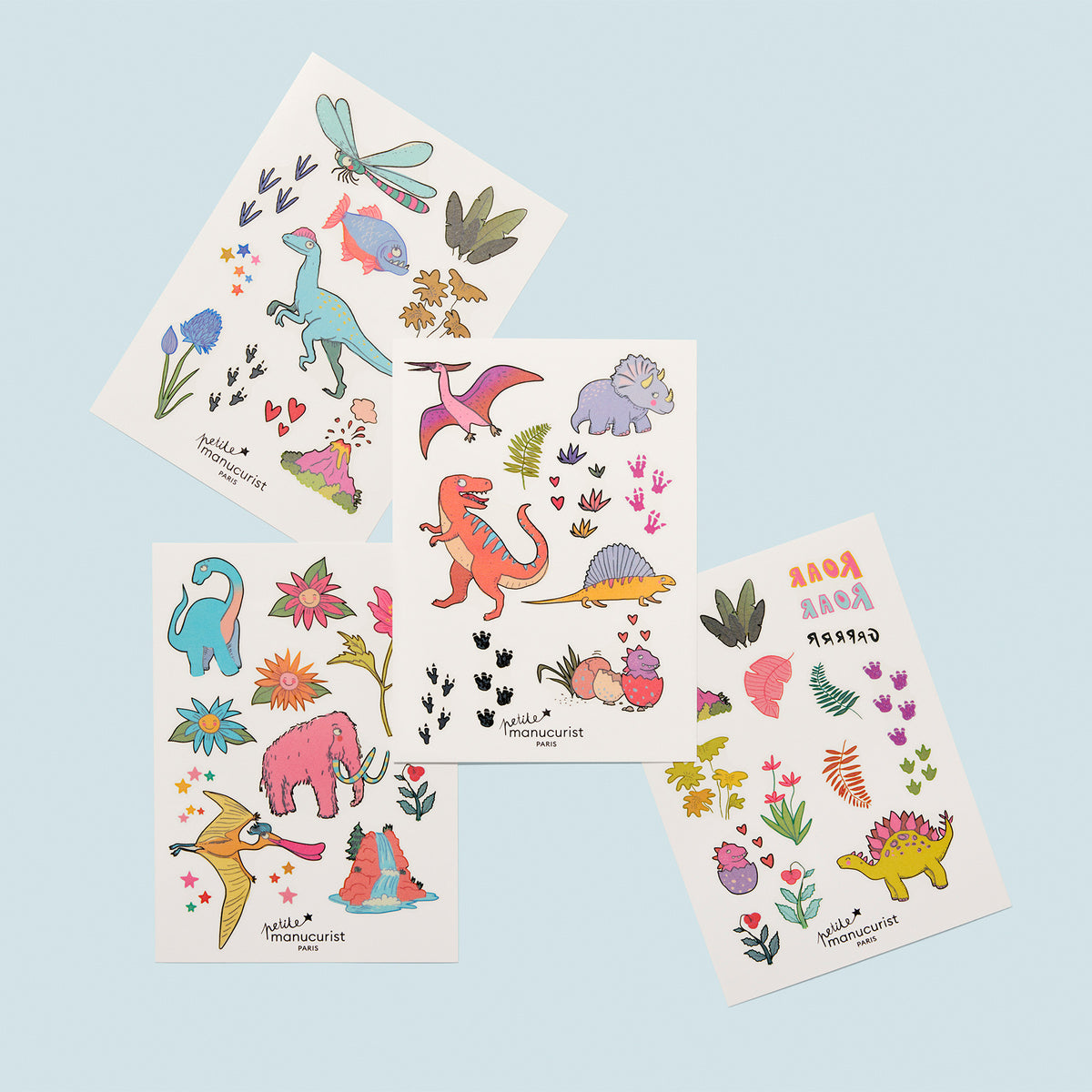 Wild Life Tattoos by Manucurist includes four sheets of colorful stickers with cartoon dinosaurs, prehistoric animals, plants, flowers, and dinosaur footprints on light blue—great for decorating notebooks or as playful body tattoos for back-to-school.
