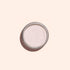 A round tin of Manucurist Pink Glazed Effect Powder displays its delicate pearlescent sheen, photographed against a pale peach background.