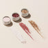 Three small round Manucurist Glitters and Effect Powders Trios in white, rose, and gold, each shown with a matching swatch of loose powder spread out in front on a light background.