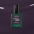 A bottle of Manucurist Queen of Night gel nail polish stands against a dark, glossy backdrop. The bottle features a deep green shade, black cap, and crisp white text on the label.