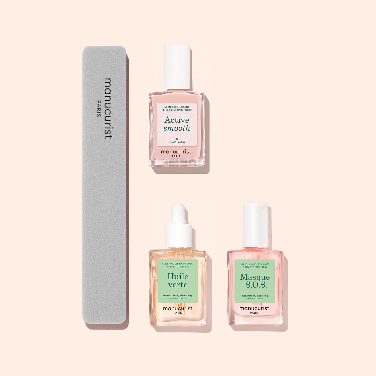Three bottles from Manucurist’s Basic Routine - Ridged Nails set and a gray nail file are arranged on a pale pink background. The bottles in the set—Active Smooth, Huile Verte, and Masque S.O.S.—are each formulated to address issues like ridged nails and provide nourishing cuticle care for healthier-looking hands.