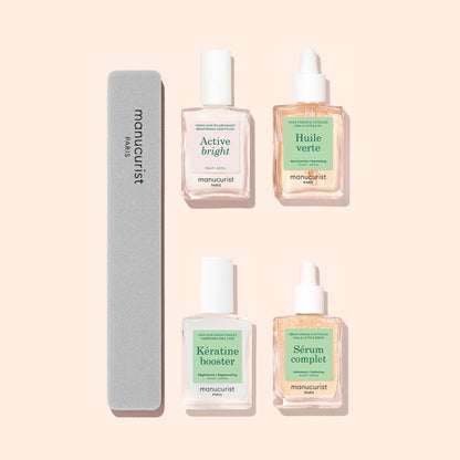 Four manicure essentials from Manucurist’s Basic Routine - Yellow Nails and a gray nail file rest on a light beige background, featuring Active Bright for nail brightening, Huile Verte cuticle oil, Kératine Booster, and Sérum Complet—all crafted by Manucurist.