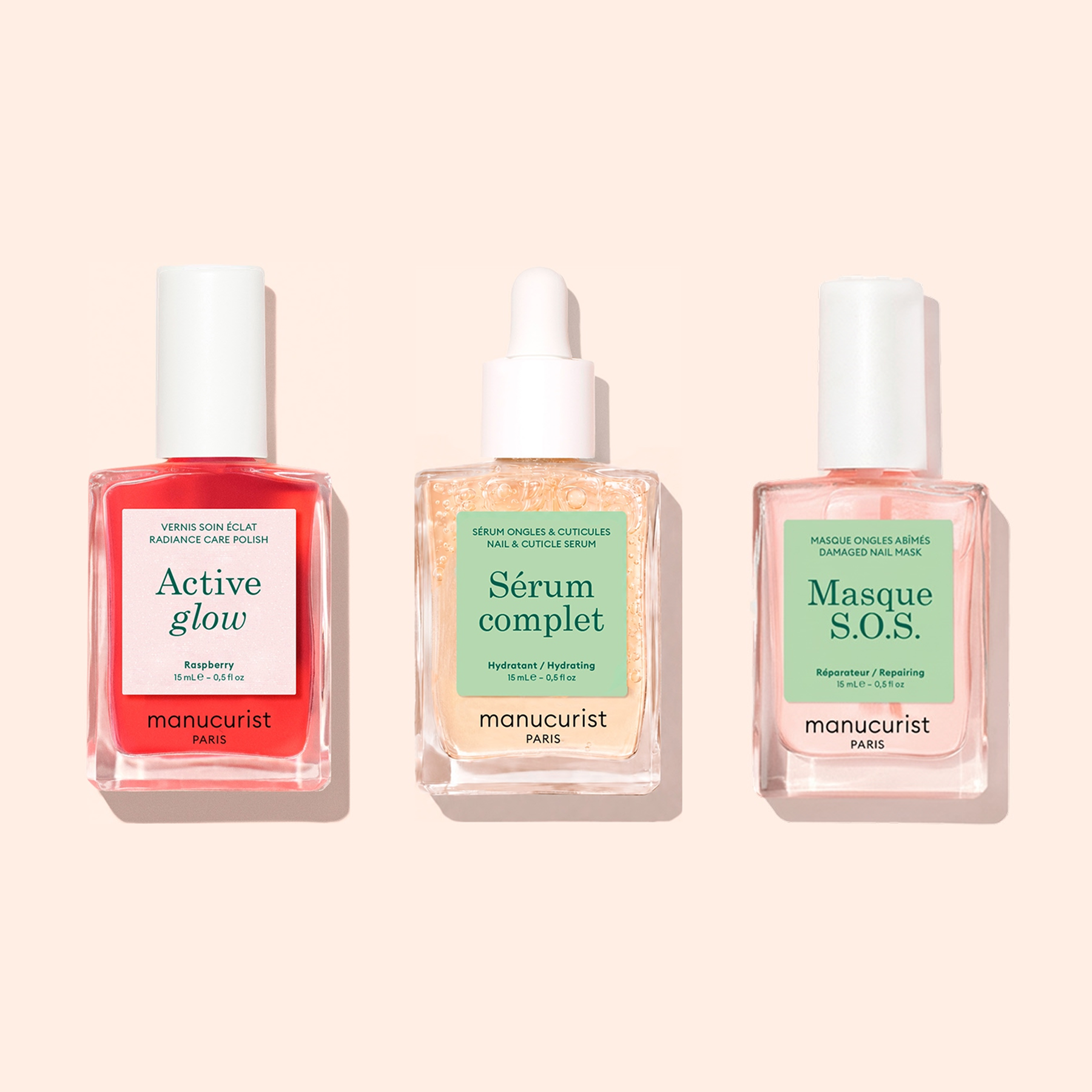 Three manicure bottles from Manucurist’s Basic Routine - Sensitive Nails—each formulated for advanced nail care—are displayed side by side on a pale peach background. This collection, crafted specifically for sensitive nails, offers everything from a hydrating polish to nourishing treatments, making it ideal for revitalizing nails and maintaining healthy hands.