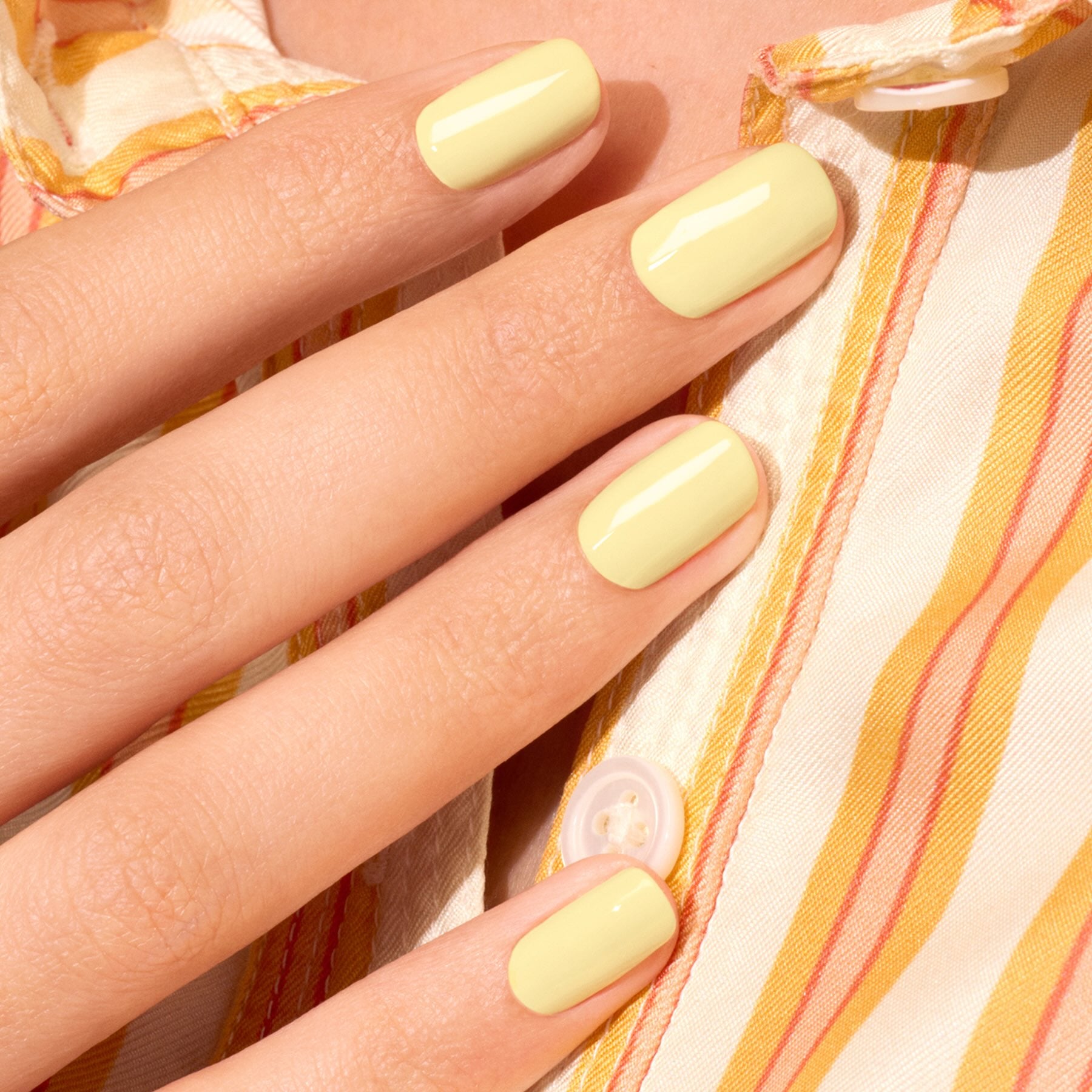A hand with neatly manicured nails painted in Manucurist&