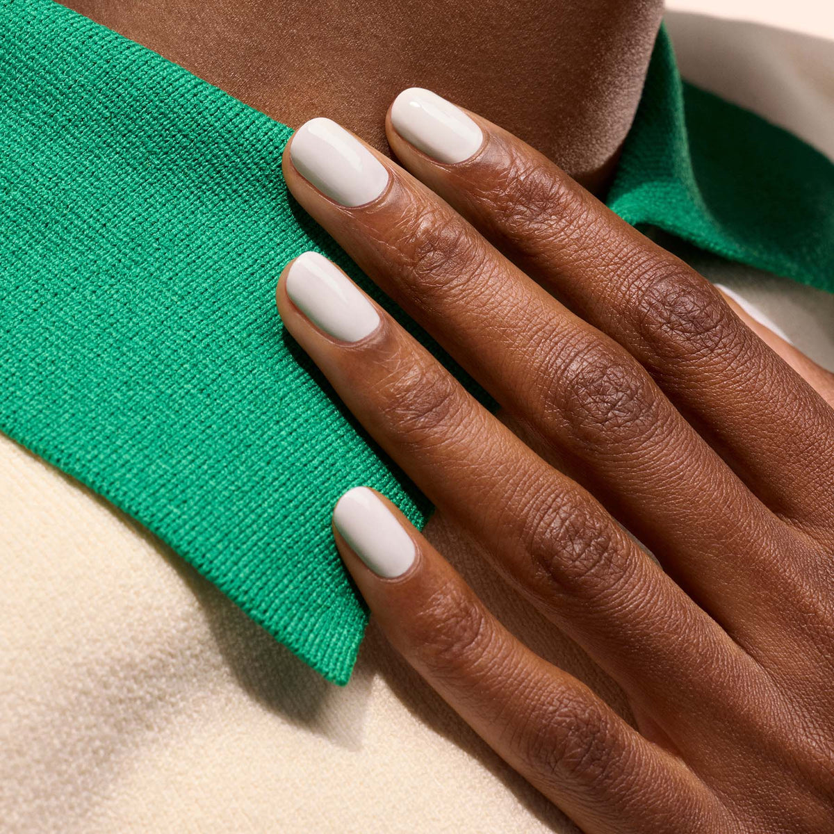 A close-up of a hand with short, neatly manicured nails painted in Manucurist&