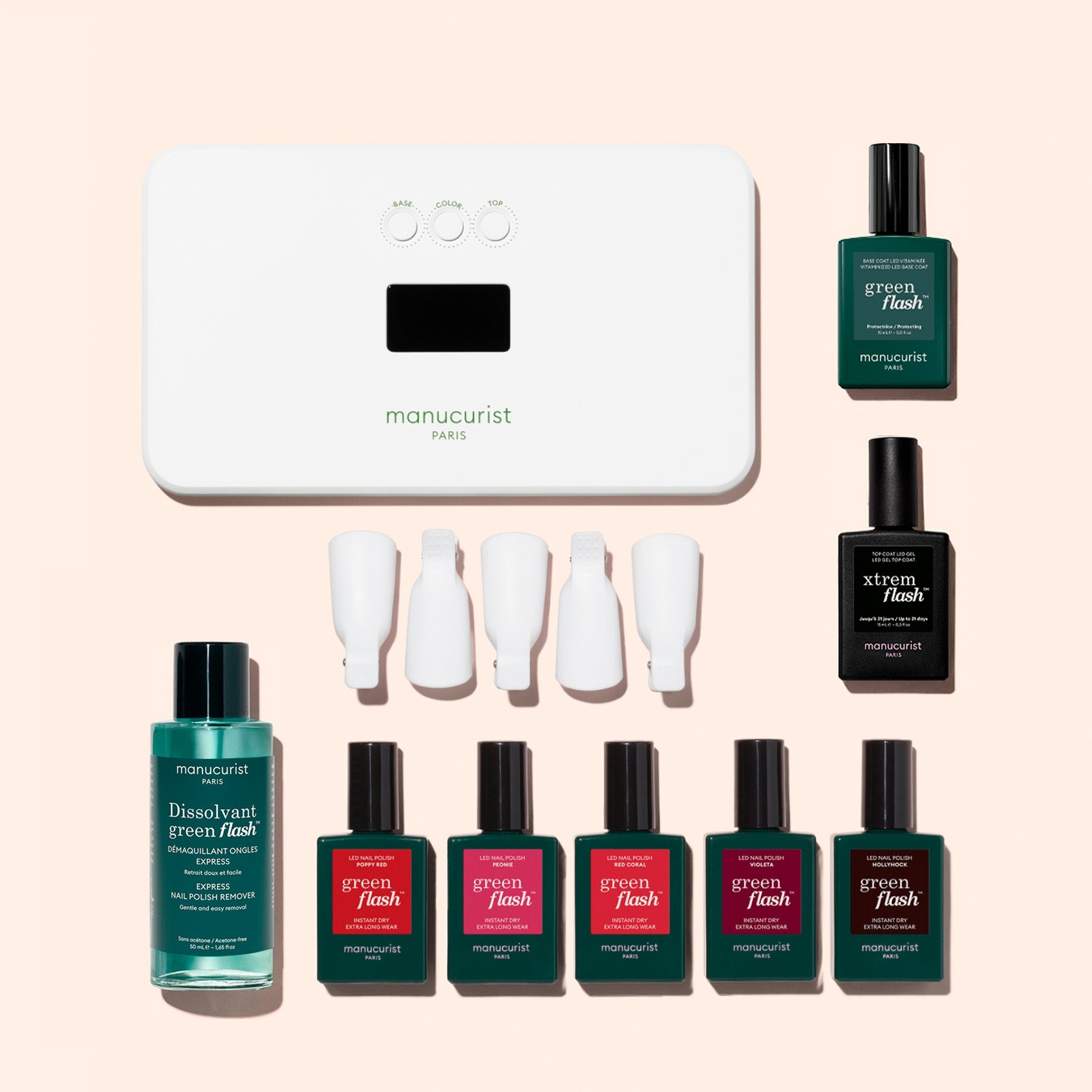 The Manucurist Super Starter Kit includes a nail lamp, four nail polish bottles, a vitaminized base coat, one remover bottle, four white nail clips, and three black bottles—all thoughtfully arranged on a light background for an ultra-glossy manicure.
