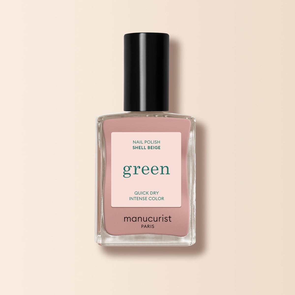 A bottle of Manucurist Shell Beige nail polish from the Green range, featuring a black cap and a label that says "green, quick dry intense color"—a light beige shade ideal for fans of delicate pinkish beige tones.