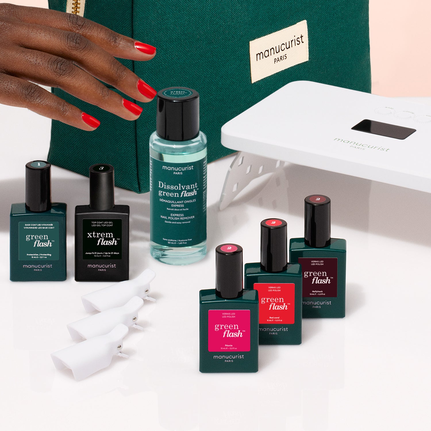 A hand with red nails is beside Manucurist&