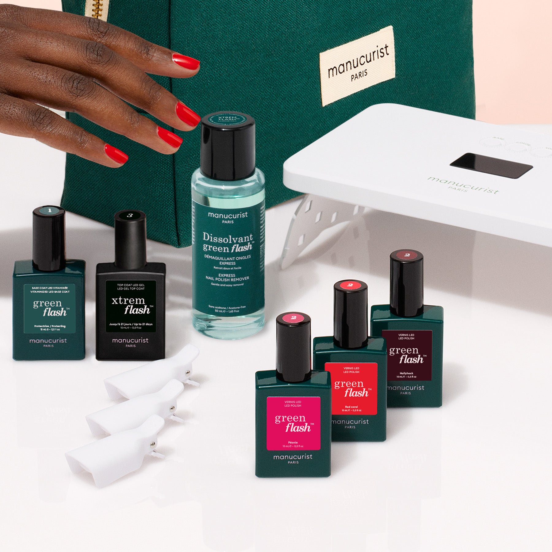 A hand with red nails is beside Manucurist&