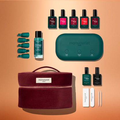 Manucurist Green Flash™ Starter Kit containing a green LED lamp, five polish colors, base and top coats, remover, finger clips, files, and a burgundy carrying case for a salon-style manicure at home.