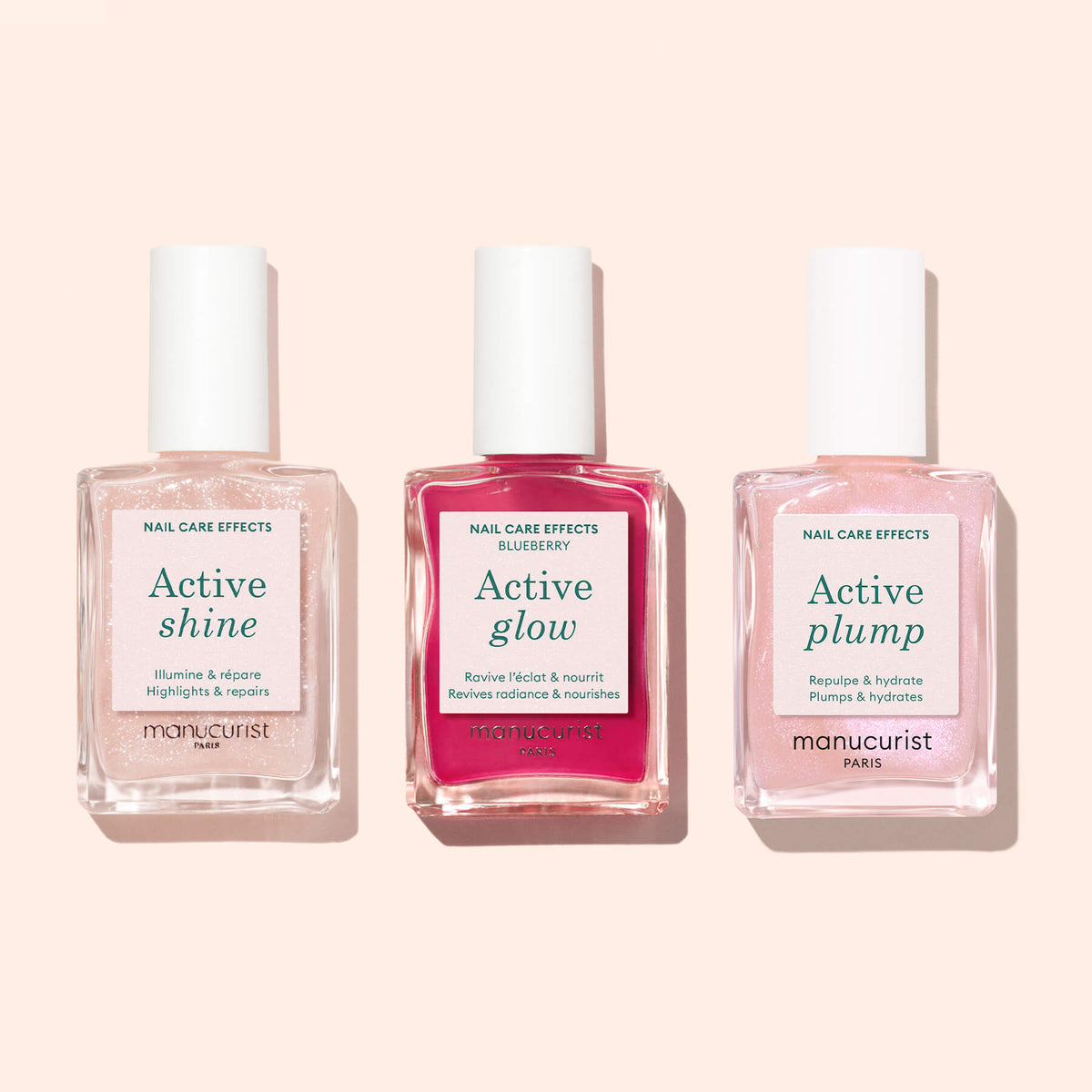 Three bottles of Manucurist nail care products—including the Active™ Shine Opal—are arranged side by side on a pale pink background, highlighting advanced plant-based nail polish and nourishing formulas designed for strong, radiant nails.