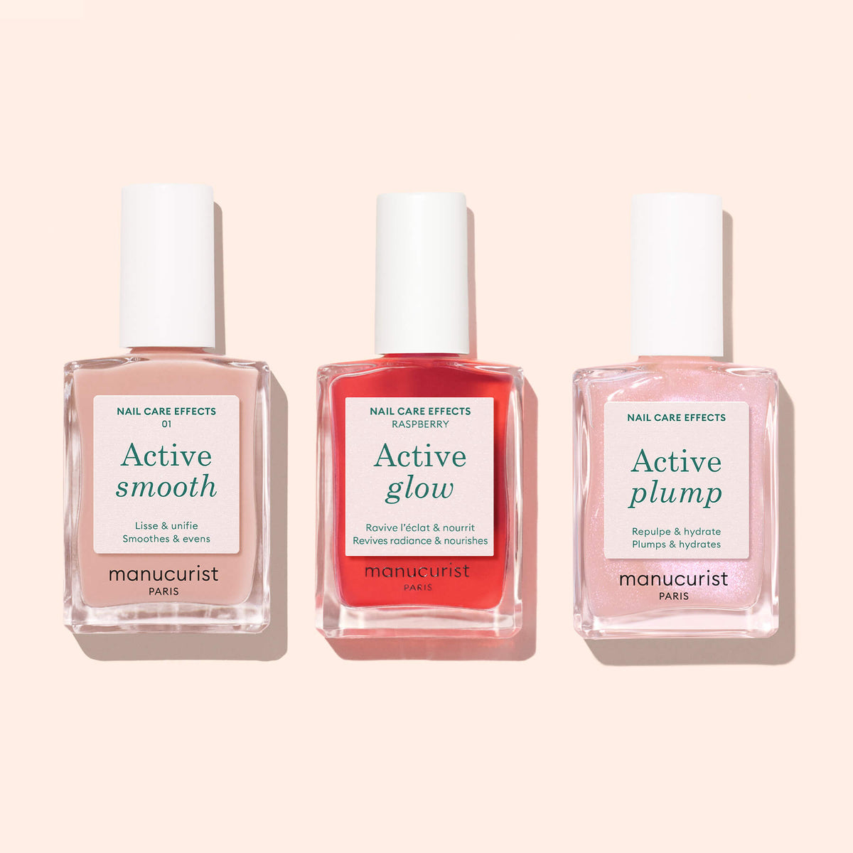 Three bottles of Manucurist plant-based nail care products—Active™ Smooth 01, Active Glow, and Active Plump—stand side by side against a light pink background.
