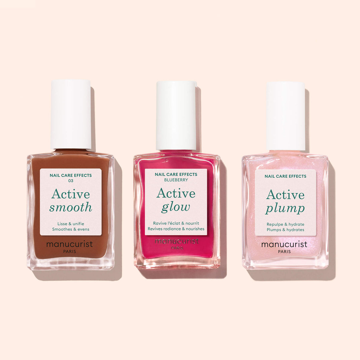 Three square nail polish bottles from Manucurist, labeled Active™ Smooth 03, Active Glow, and Active Plump, stand side by side on a pale pink background. Each offers a different CC Polish Treatment for advanced nail care: rich brown with a Bronze Satin Finish, vibrant pink, and delicate light pink.