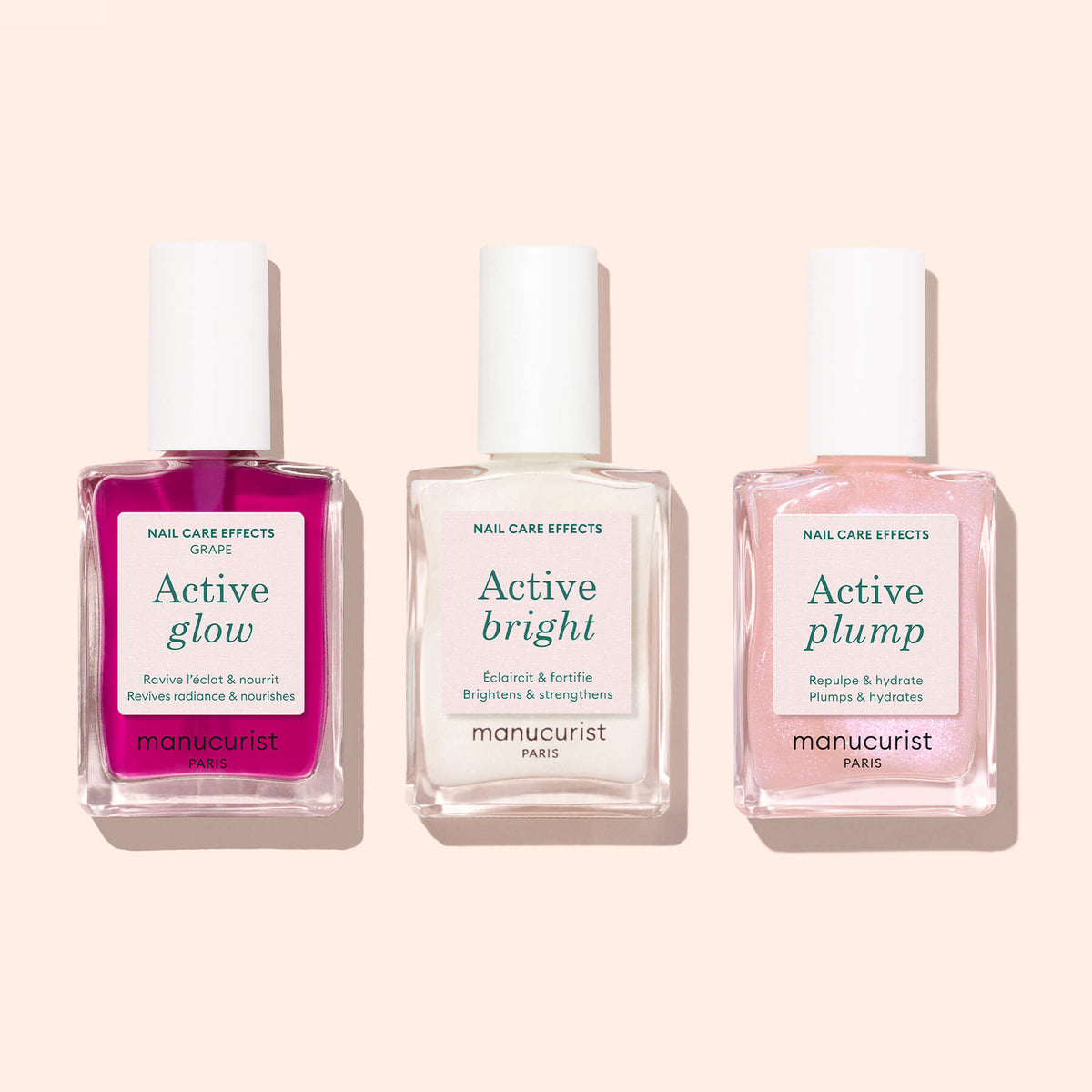 Three Manucurist nail polish bottles—including Active™ Glow Grape—are arranged side by side on a light background. Featuring shades of purple, white, and pink such as a delicate lilac, these formulas are designed to enhance your natural shine while providing exceptional nail care.