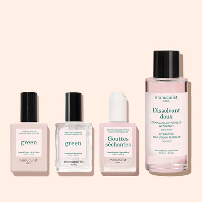 Four manicure products in bottles are arranged in a row on a light pink background. Among them are green, Gouttes séchantes for express air-drying, Dissolvant doux, and Glitter Top Coat by Manucurist.