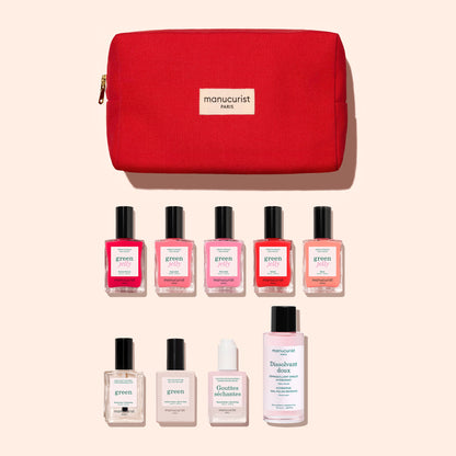A red Manucurist organic cotton pouch with a gold zipper is displayed above nine manicure essentials—including gel-effect nail polishes, a bottle of nail polish remover, and a hydrating drops bottle—all beautifully arranged on a light background as part of the Manucurist Super Starter Kit - Jelly Nail Polish.