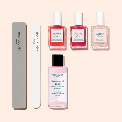 The Manucurist Active™ Manicure Kit features two nail files for seamless nail preparation, three pink-toned nail treatment bottles, and a gentle nail polish remover—providing everything needed for a flawless manicure, beautifully arranged against a light beige backdrop.