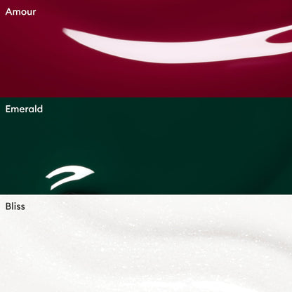 Three color swatches from Manucurist’s Customisable Trio Green—Amour (deep red), Emerald (dark green), and Bliss (white with shimmer)—each feature a smooth, glossy texture with a reflective curved highlight, perfect for creating your personalized nail polish trio or discovering on-trend green shades.