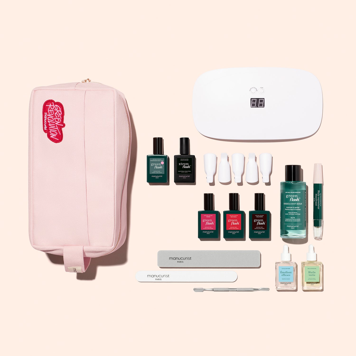 The Manucurist Addict Kit includes a pink zippered pouch, Green Flash gel polish, UV nail lamp, nail files, cuticle pusher, and manicure essentials—everything you need for an ultra-glossy manicure on a light beige background.