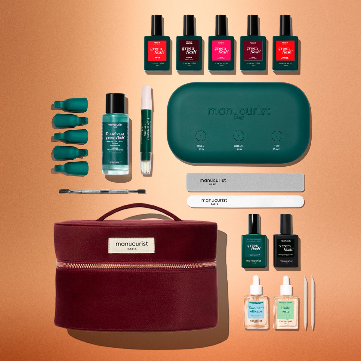 A burgundy storage case containing a Green Flash™ Addict Kit Gift Set, including an oval LED lamp, five colored polishes, a top coat, base coat, nail remover, tools, and files.