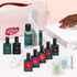 The Manucurist Super Addict Kit includes Green Flash gel polish, nail care tools, remover, vitaminized base coat, cuticle oil, nail files, a pink pouch, and creates a red ultra-glossy manicure under a nail lamp.