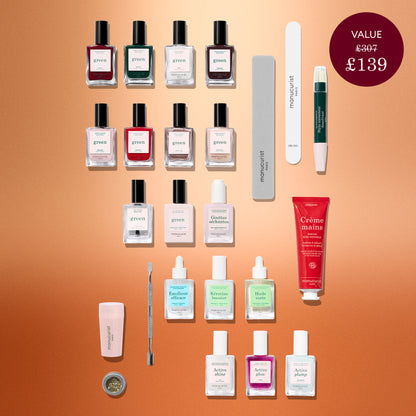 A flat lay of Manucurist’s Advent Calendar Time to Shine! featuring an assortment of nail care essentials—including nail polishes, files, a cuticle pusher, hand cream, Active Shine Icy treatment bottles, and a nail brush—neatly arranged on a copper background.