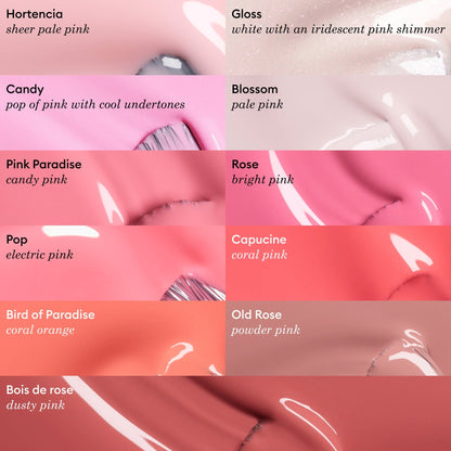 Rows of creamy Manucurist nail polish swatches in pink and coral shades, each labeled with a name—like Blossom—and a brief color description, ranging from sheer pale pink to dusty pink.