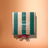 A box featuring pink and green stripes, labeled “Manucurist Advent Calendar Time to Flash!”, ideal for gel polish manicure enthusiasts, rests on a peach background with a red ribbon at the bottom.