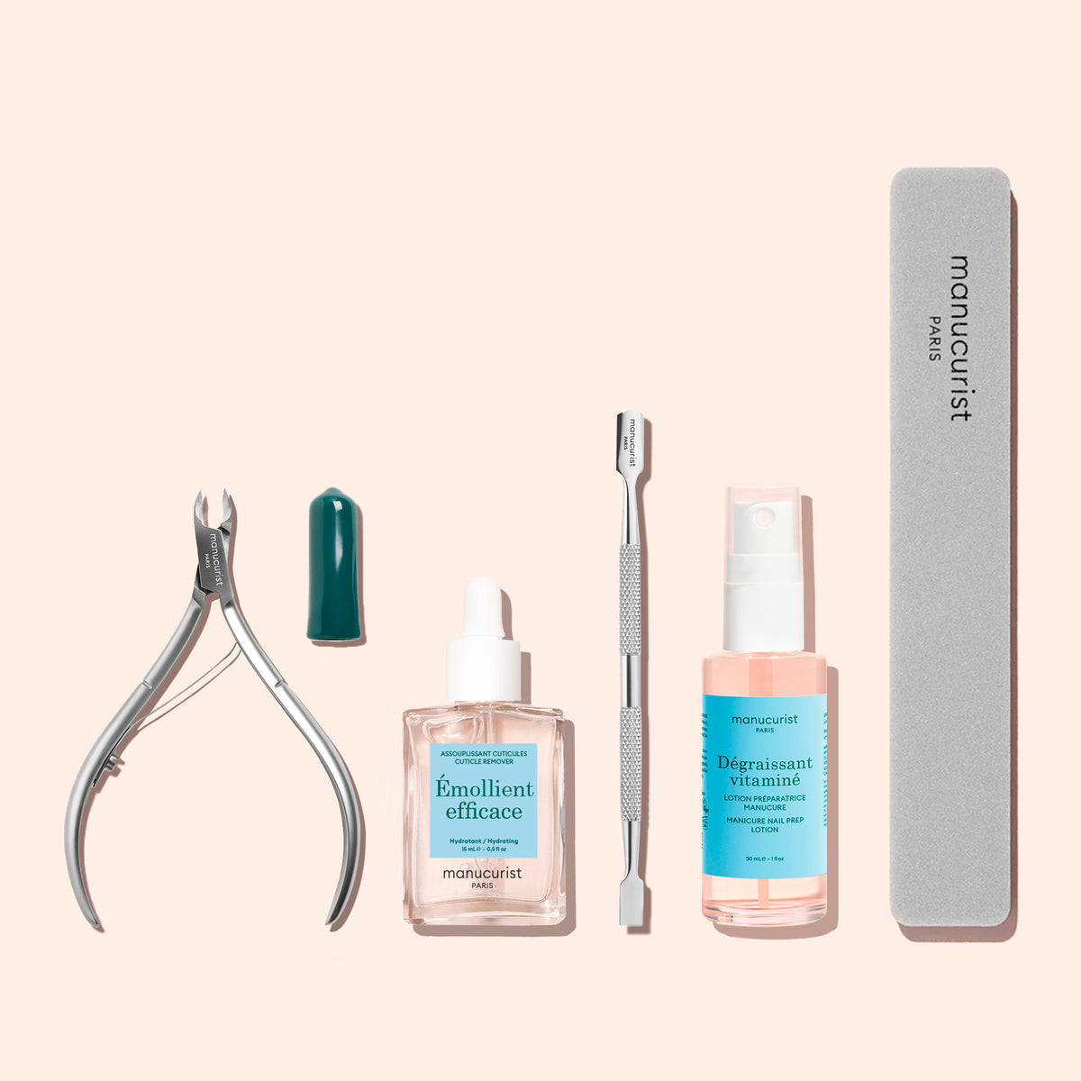 Manucurist Cuticle nippers, featuring a green cap emollient dropper bottle, a stainless steel cuticle pusher, nail prep liquid, and a manicure nail file—all arranged neatly on a light beige background.