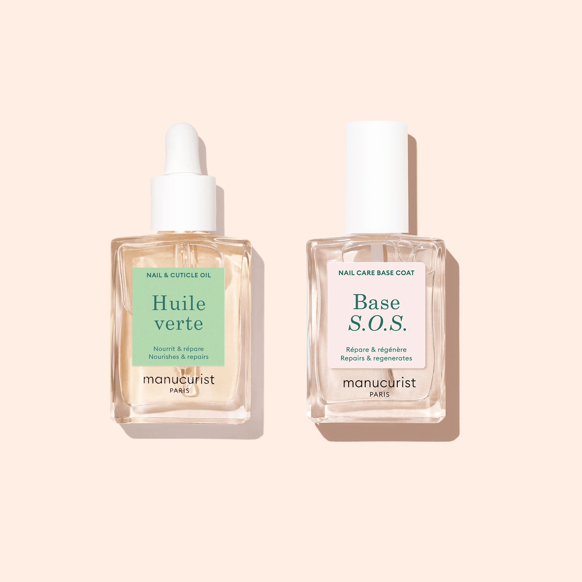 Two clear bottles on a beige background: one is Manucurist Nourishing Cuticle Oil with a dropper cap, the other is labeled Base S.O.S. with a regular cap—essentials for hydrated nails from Manucurist.