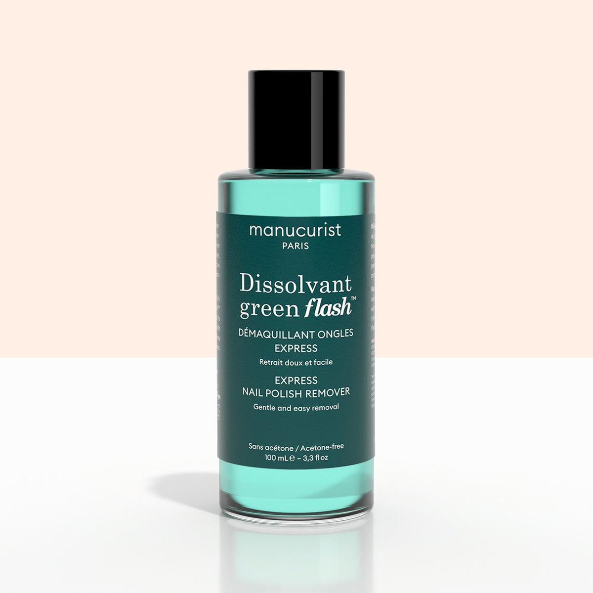 A bottle of Manucurist Green Flash™ Gel Polish Remover, featuring a black cap and green liquid, with a label highlighting its moisturizing, soothing formula ideal for removing gel polish.