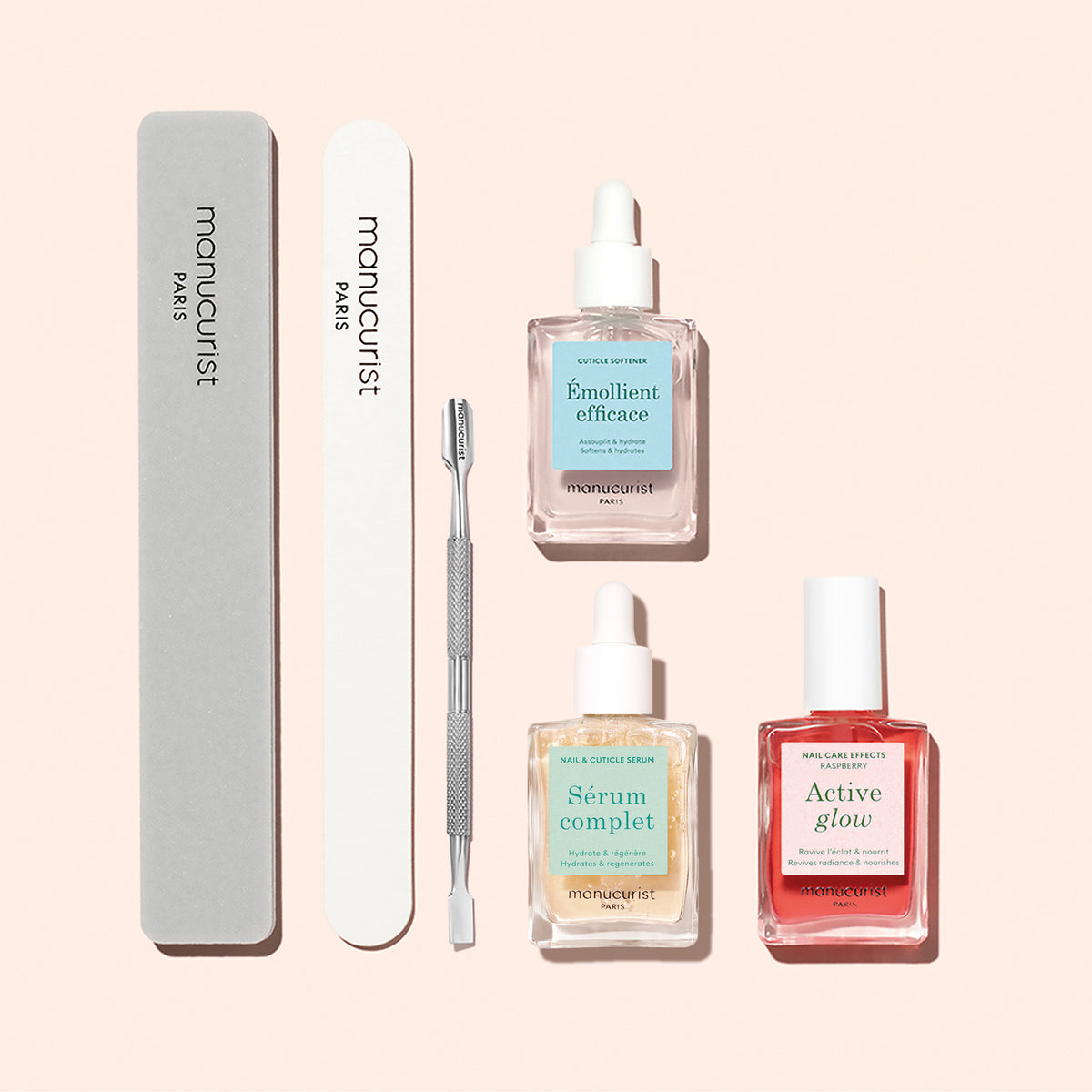 The Manucurist Healthy Glow Duo, along with manicure tools, is arranged neatly on a light pink background.