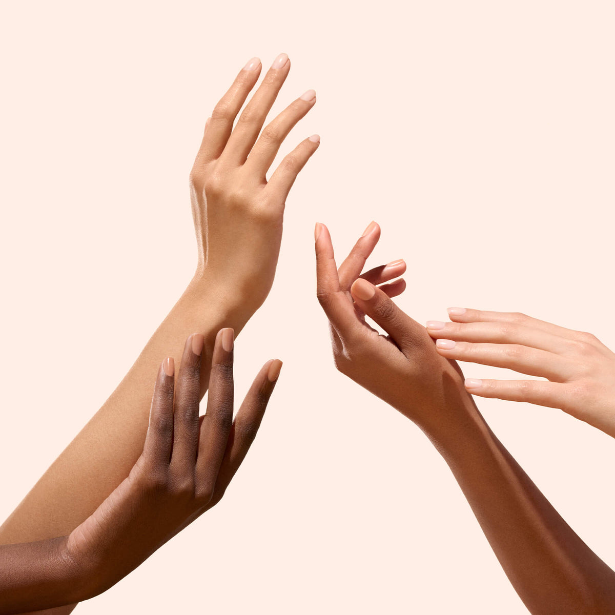 Four hands with diverse skin tones, each showcasing Manucurist&