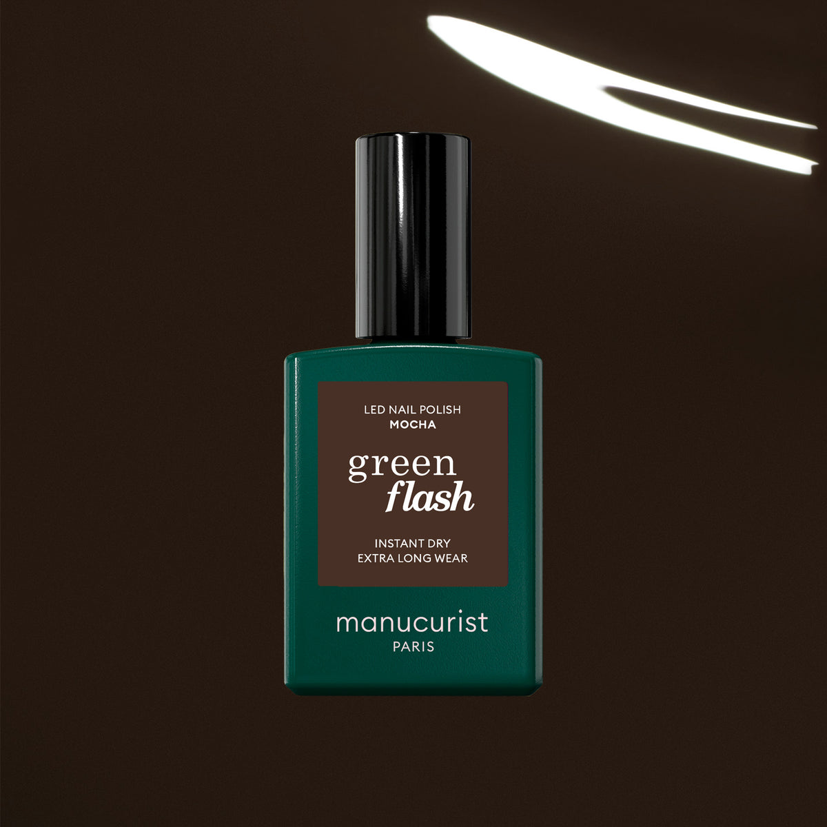 A green bottle of Manucurist Mocha gel polish, in a rich dark brown shade, is shown against a deep brown background with a curved white light reflected above.