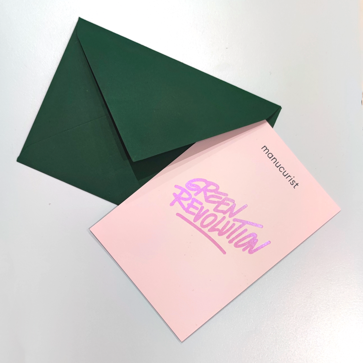 A Manucurist Gift Card with a green envelope and pink note, plus a pink envelope—ideal for green gifting or presenting your gift card in style.