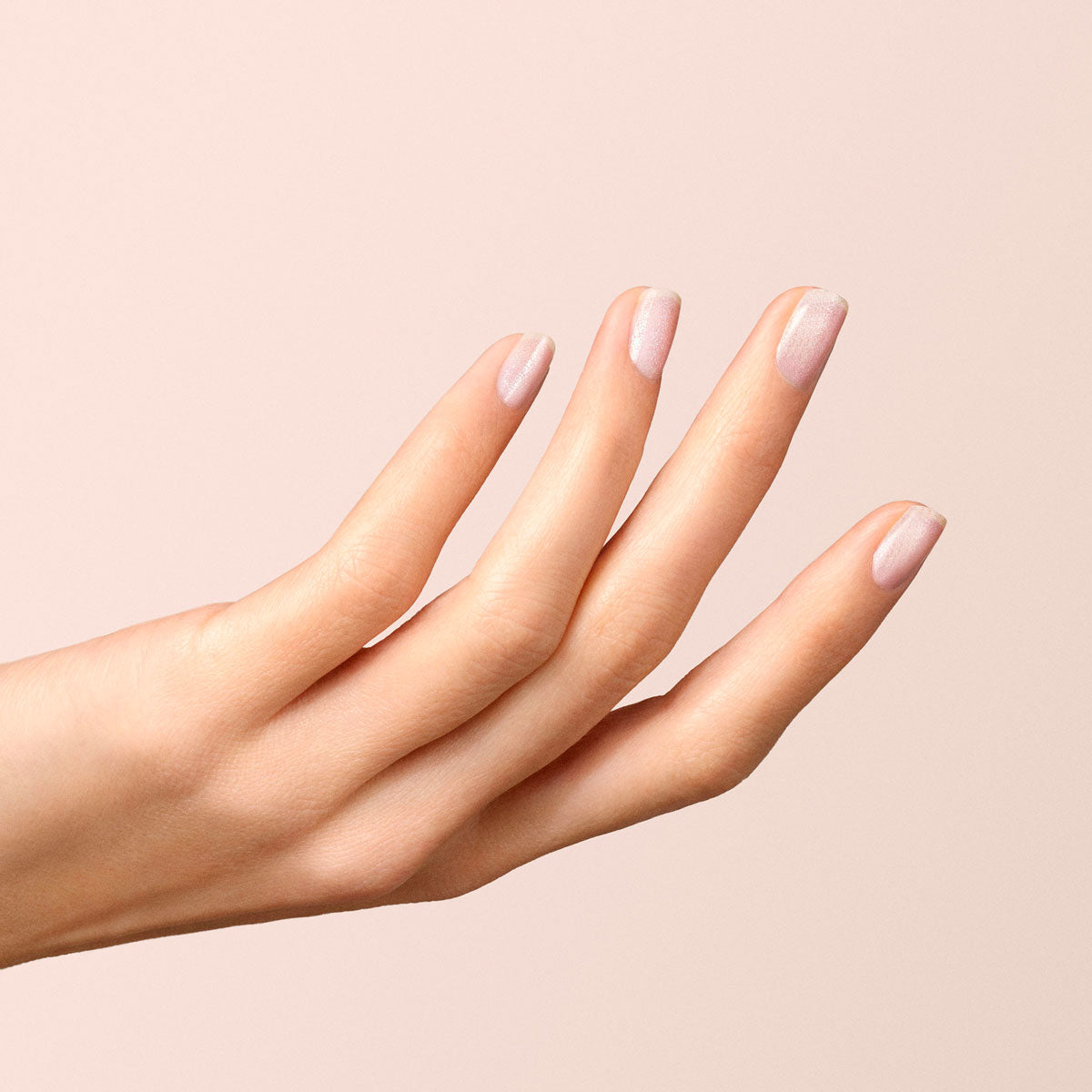A close-up of a light-skinned hand with neatly manicured nails painted in Manucurist&